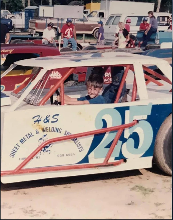Young Tyler Hudson sitting in a race car